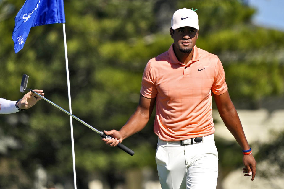 Tony Finau hands his club to his caddy on the second green during the second round of the Tournament of Champions golf event, Friday, Jan. 7, 2022, at Kapalua Plantation Course in Kapalua, Hawaii. (AP Photo/Matt York)