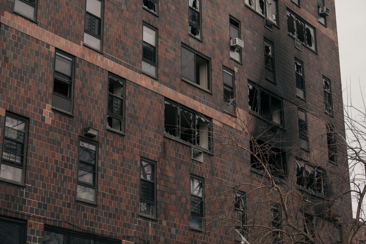 Broken windows and charred bricks mark the exterior of a 19-story residential building after a fire erupted in the morning on Jan. 9, 2022, in the Bronx borough of New York City.