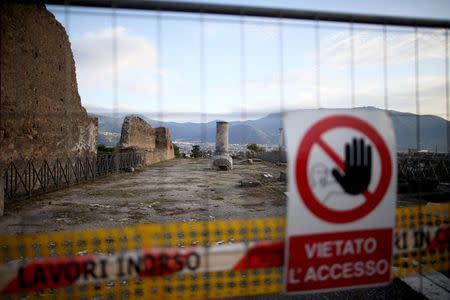 A sign hanging on a fence reading "prohibited access" is seen along ancient Roman cobbled street at the UNESCO World Heritage site of Pompeii, October 13, 2015. REUTERS/Alessandro Bianchi