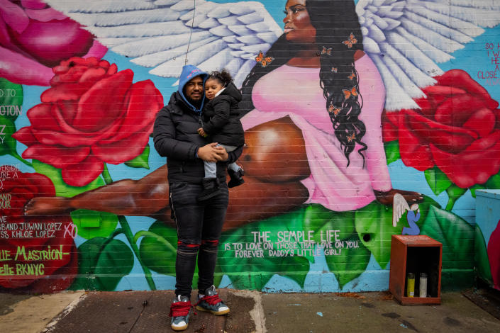 Juwan Lopez and his daughter Khloe, 2, at a mural memorializing Sha-Asia Semple, his partner and the girlÕs mother, in Brooklyn, Jan. 12, 2023. (Desiree Rios/The New York Times)