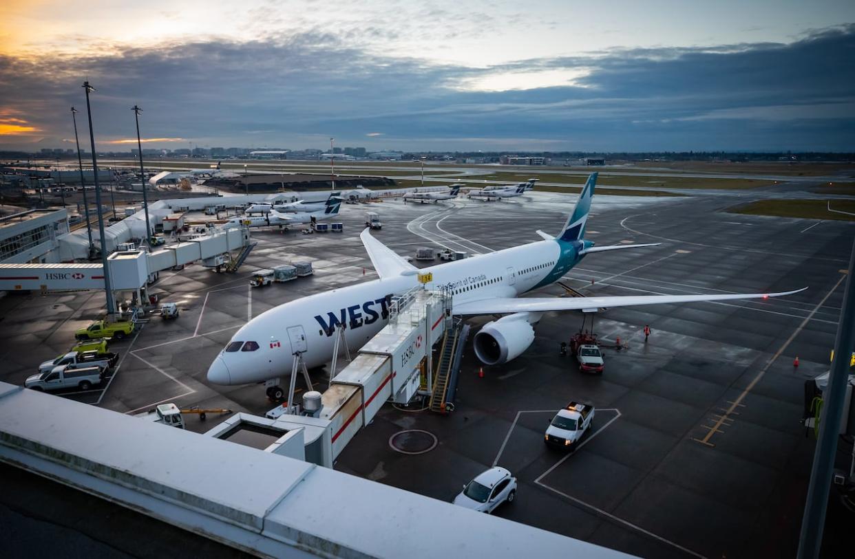 A WestJet Airlines Boeing 787-9 Dreamliner is seen parked at a gate at Vancouver International Airport, in Richmond, B.C., on Jan. 21, 2021. (Darryl Dyck/The Canadian Press - image credit)
