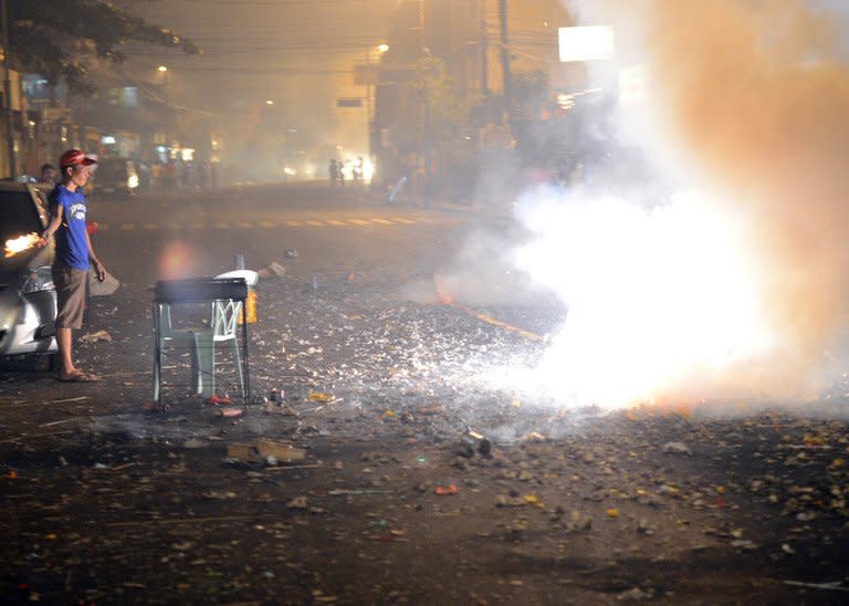 Revellers set off firecrackers to usher in New Year's Day in Manila, early on January 1, 2013. Celebratory gunfire killed a four-year-old boy and more than 200 others were injured by powerful firecrackers in typically rowdy New Year celebrations in the Philippine capital