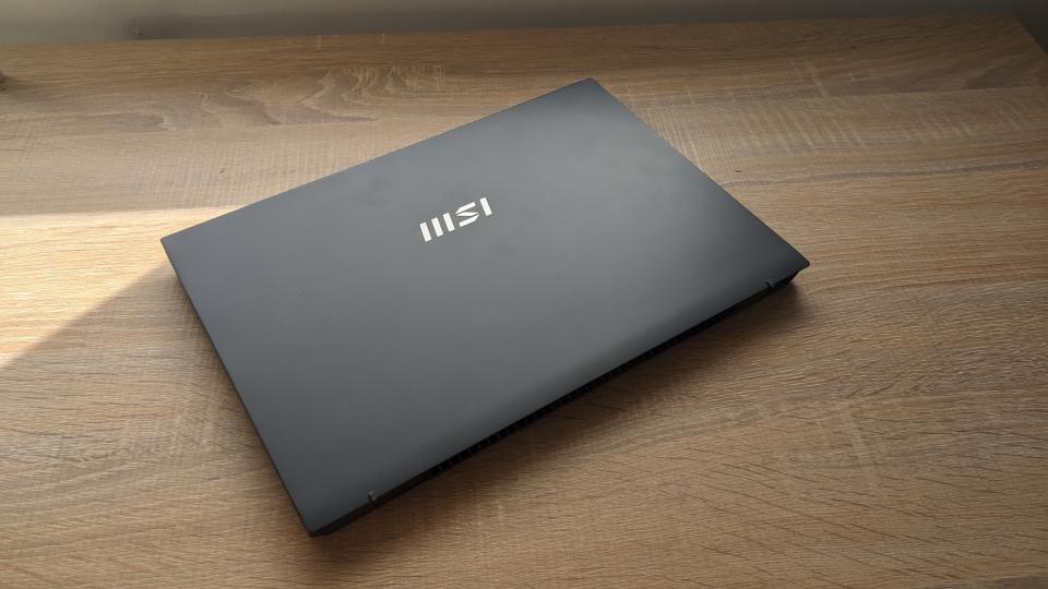 The MSI Prestige 13 Evo ultrabook pictured on a wooden desk.