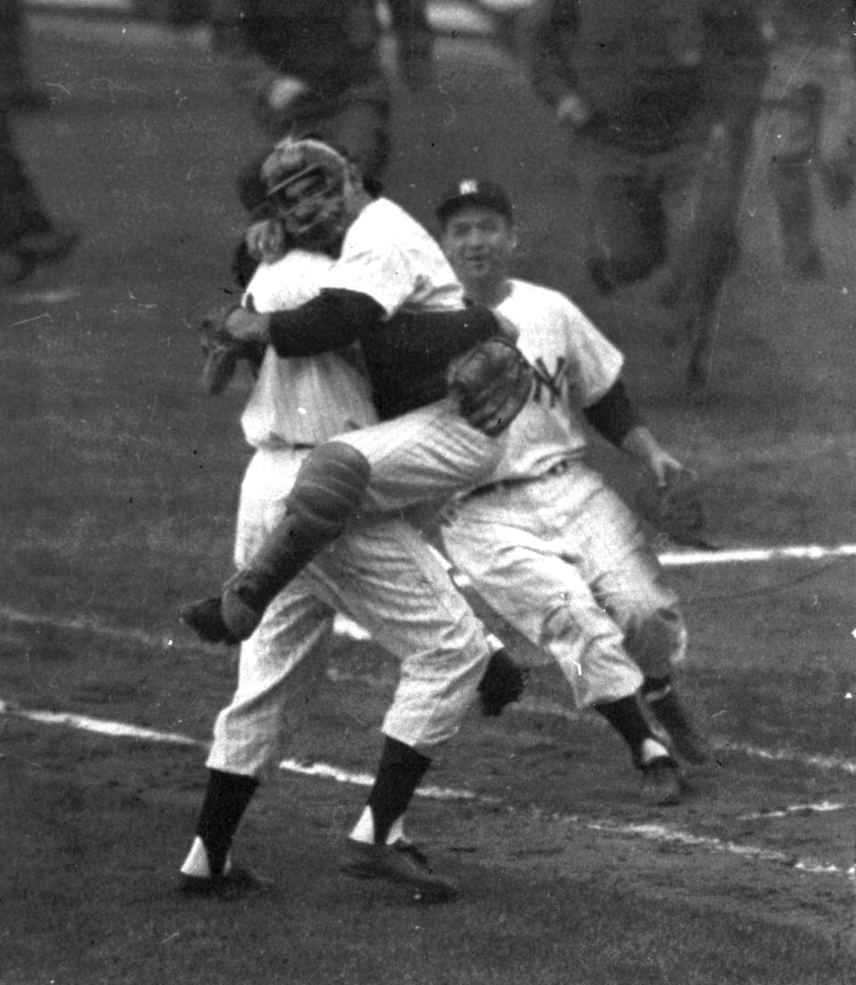 FILE - New York Yankees catcher Yogi Berra is embraced by pitcher Don Larsen as he leaps into Larsen's arms at the end of Game 5 of baseball's World Series against the Brooklyn Dodgers at New York's Yankee Stadium, Oct. 8, 1956. Larsen pitched a perfect game. “It Ain’t Over,” a 98-minute documentary on Yogi Berra's life, aims to elevate his playing career alongside his status as a cultural icon. The Sony Pictures Classics film opens Friday, May 12, 2023, in theaters in the New York tri-state area and Los Angeles following its premiere last June at the Tribeca Festival. (AP Photo, File)