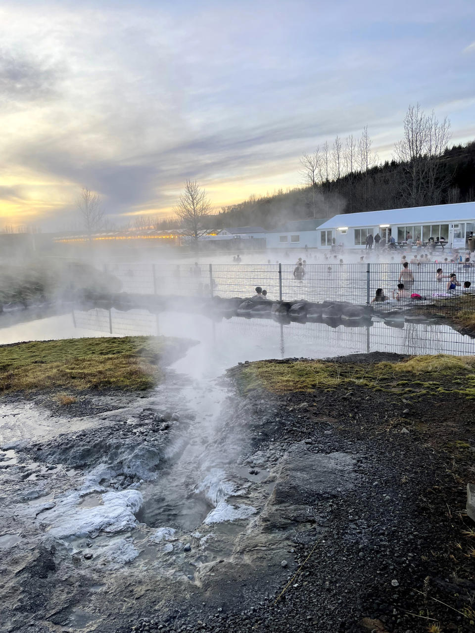 This Nov. 16, 2023 image provided by Beth Harpaz shows steam emanating from hot springs that supply geothermally heated water for the Secret Lagoon in the Hverahólmi geothermal area off Iceland's Golden Circle route. The lagoon's outdoor pool is open year-round with water heated to just over 100 F (38-40 C). (Beth Harpaz via AP)