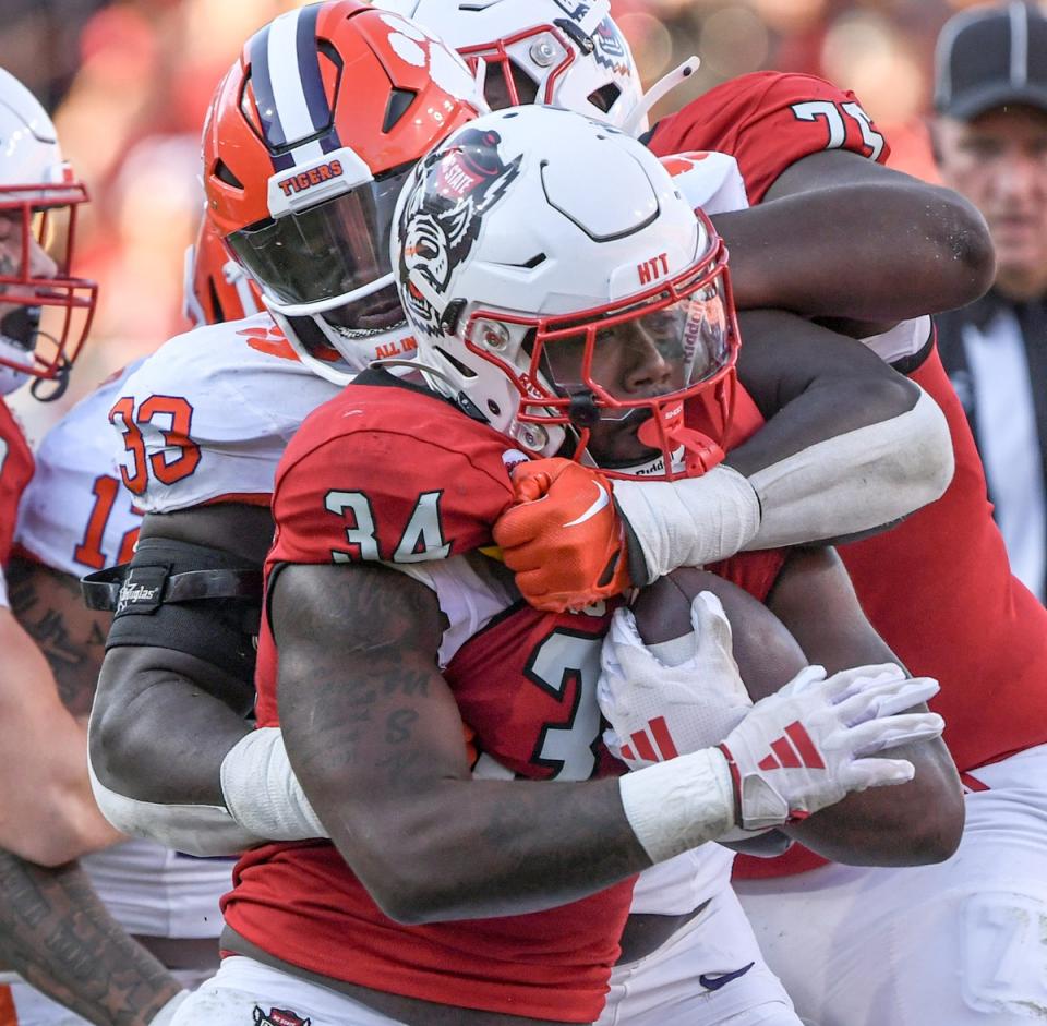 Clemson defensive tackle Ruke Orhorhoro (33) tackles North Carolina State running back Delbert Mimms III (34) during the fourth quarter at Carter-Finley Stadium in Raleigh, N.C. Saturday, October 28, 2023.