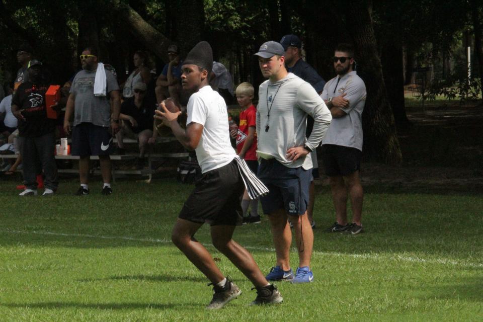 UWF head coach Kaleb Nobles (right) watches one of the quarterbacks during a drill at the UWF football camp on Saturday, July 15, 2023.