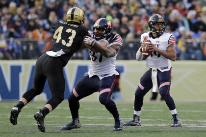 Navy quarterback Keenan Reynolds, right, looks for a receiver as teammate Chris Swain blocks Army linebacker James Kelly. Saturday, Dec. 13, 2014, in Baltimore. (AP Photo/Patrick Semansky)