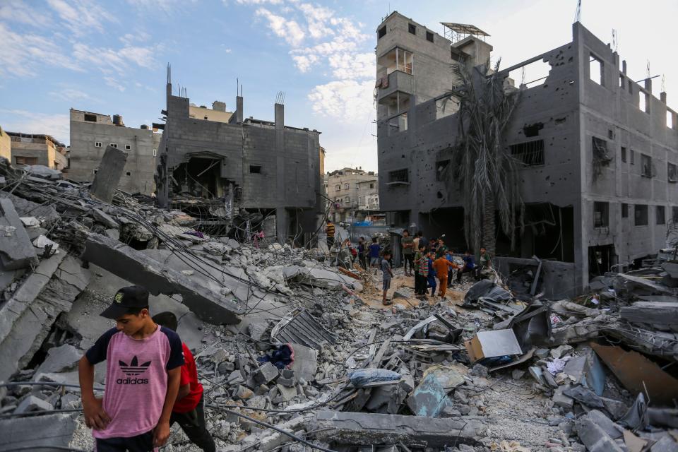 People search through buildings that were destroyed during Israeli air raids in the southern Gaza Strip on October 27, 2023 in Khan Yunis, Gaza.