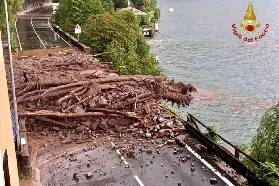 Mud and trees block a road in the Lake Como area, northern Italy, Tuesday, July 27, 2021. Towns around Italy's Lake Como hit by mudslides and floods on Tuesday, in yet an extreme example of extreme weather phenomenon that an agricultural lobby said Tuesday has intensified in recent years. Italian firefighters carried out more than 60 rescues after storms wreaked havoc around the picturesque lake ringed by mountains in northern Italy. They included bringing to safety an elderly woman blocked in her home, as well as a person with a disability and a caregiver isolated by a landslide. No deaths or injuries were reported. (Vigili del Fuoco via AP)