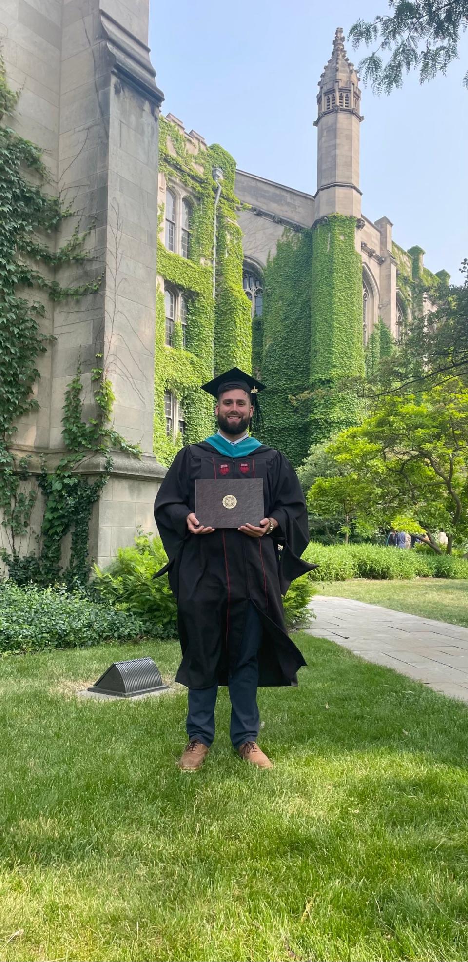 Amir Nijem displays his diploma after completing his public policy master's at the University of Chicago.