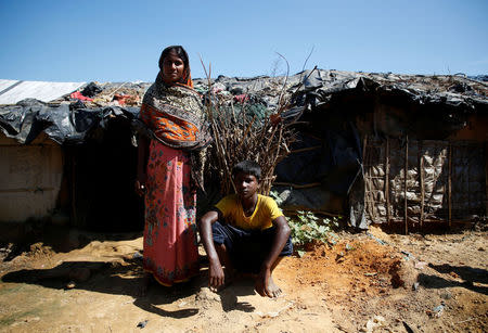 Zuhura Begum, 30, a Rohingya refugee, poses for a picture with her son Anwar Hossain, 12, outside their temporary shelter at Kutupalong refugee camp near Cox's Bazar, Bangladesh, November 12, 2017. REUTERS/Navesh Chitrakar