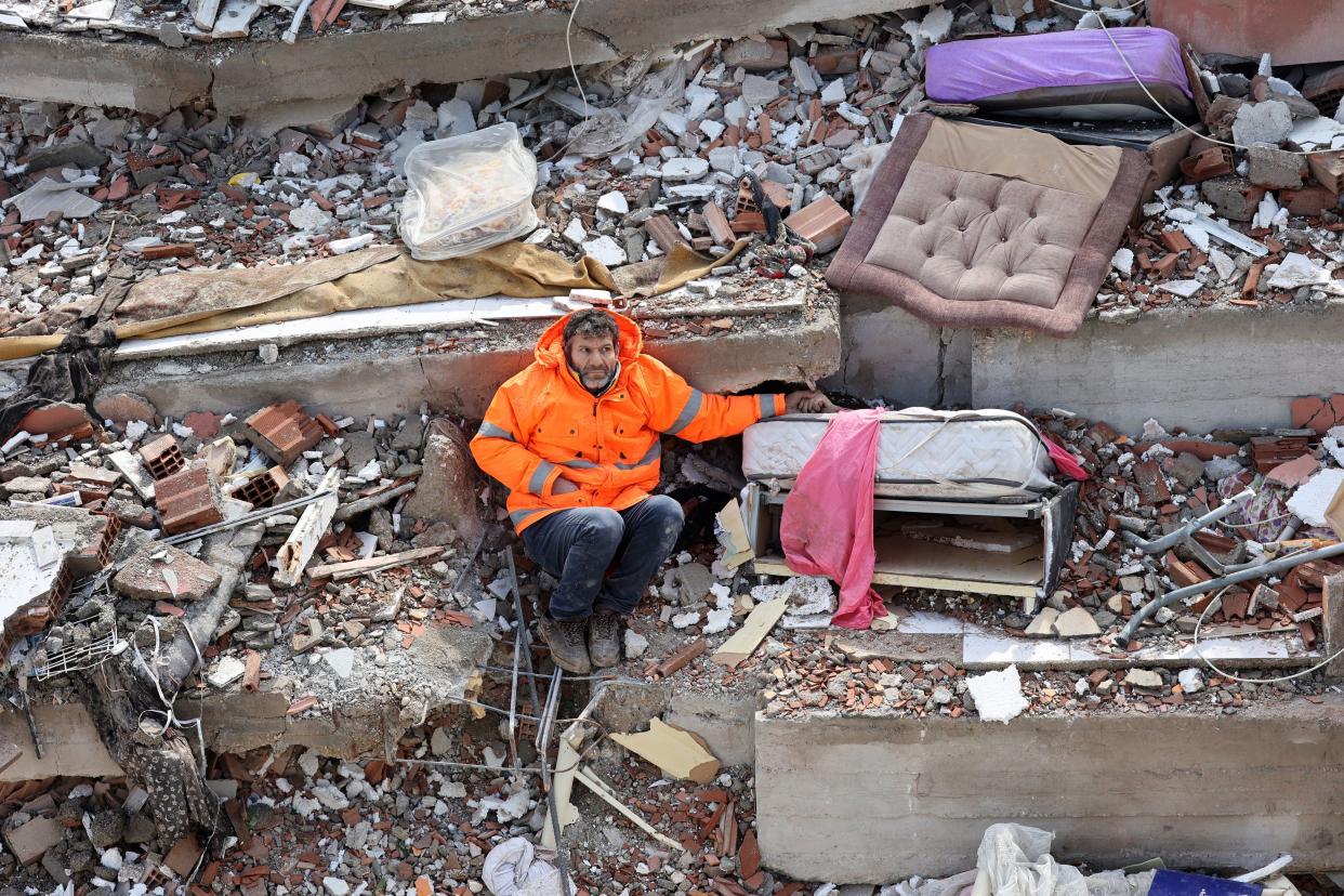 A man holds the hand of his 15-year-old daughter, who died in the earthquake in Kahramanmaras, Turkey. 