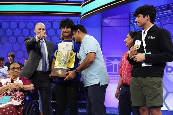 NATIONAL HARBOR, MARYLAND - JUNE 01:  Speller Dev Shah of Largo, Florida, celebrates with his father Deval Shah, mother Nilam Shah, brother Neil Shah, grandmother Vinaben Shah and E. W. Scripps Company CEO Adam Symson after he won the 2023 Scripps National Spelling Bee at Gaylord National Hotel and Convention Center on June 1, 2023 in National Harbor, Maryland. Shah correctly spelled the word 