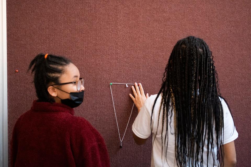 Middle schoolers Claire Davidson, right, and Kristen Johnson, left, work on a Picture-Hanging Puzzle during a workshop led by Ranthony A.C. Edmonds, an ascending postdoctoral researcher in mathematics at Ohio State, who teaches local middle schoolers STEM lessons by teaching them about Black mathematicians.