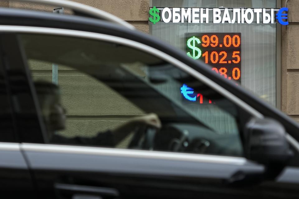 A woman drives past a currency exchange office in Moscow, Russia, Monday, Aug. 14, 2023. The Russian ruble has reached its lowest value since the early weeks of the war in Ukraine as Western sanctions weigh on energy exports and weaken demand for the national currency. The Russian currency passed 101 rubles to the dollar on Monday, continuing a more than 25% decline in its value since the beginning of the year. (AP Photo/Alexander Zemlianichenko)