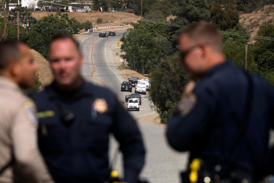 Law enforcement authorities close off a road on Tuesday during an investigation after a shooting at a Los Angeles County Fire Department station near Santa Clarita, California.