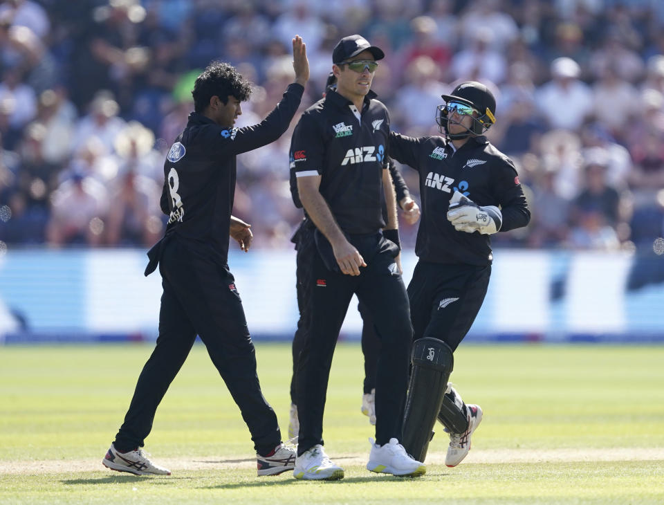 New Zealand's Rachin Ravindra, left, celebrates the wicket of England's Joe Root during the first one day international match against England, at Sophia Gardens, Cardiff, Wales, Friday Sept. 8, 2023. (Joe Giddens/PA via AP)