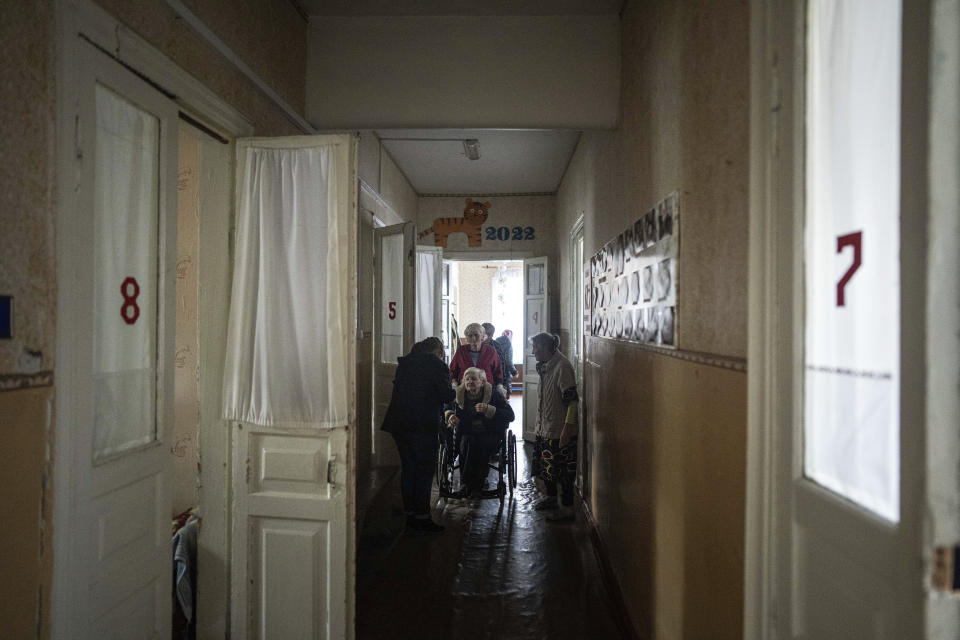 Patients talk to each other in a shelter for injured and homeless people in Izium, Ukraine, Monday, Sept. 26, 2022. A young Ukrainian boy with disabilities, 13-year-old Bohdan, is now an orphan after his father, Mykola Svyryd, was taken by cancer in the devastated eastern city of Izium. (AP Photo/Evgeniy Maloletka)