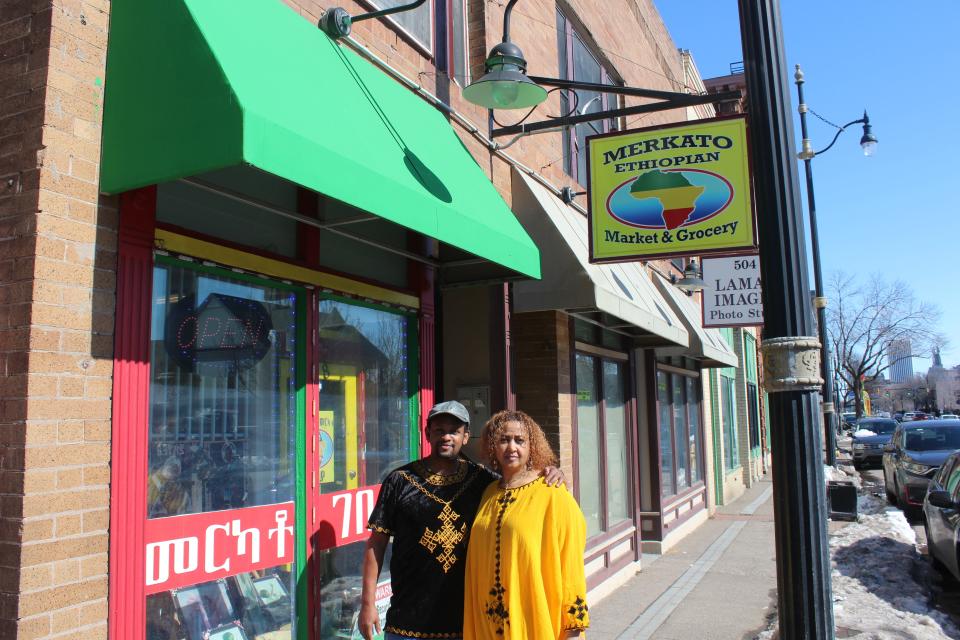 Simon Kebret and Frehiwot Mamo, the husband-and-wife duo behind Merkato Ethiopian Market & Grocery, stand outside of their brightly colored store.