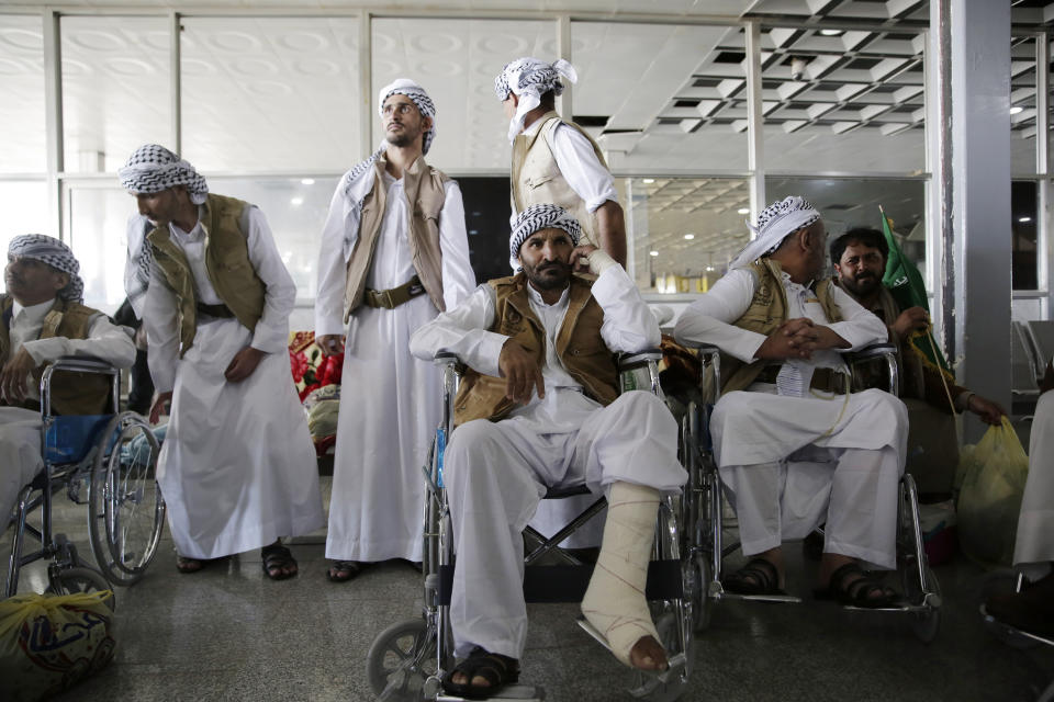 Yemeni prisoners gather during their arrival after being released by the Saudi-led coalition in the airport of Sanaa, Yemen, Thursday, Nov. 28, 2019. The International Committee of the Red Cross says over a hundred rebel prisoners released by the Saudi-led coalition have returned to Houthi-controlled territory in Yemen, a step toward a long-anticipated prisoner swap between the warring parties. (AP Photo/Hani Mohammed)