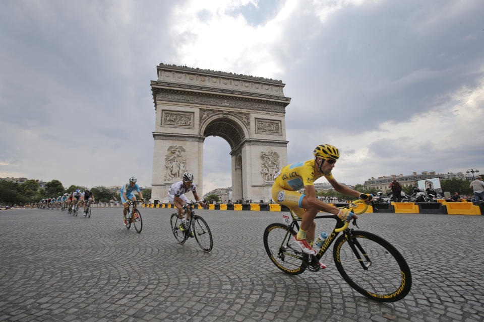 Italy's Vincenzo Nibali, wearing the overall leader's yellow jersey, passes the Arc de Triomphe during the twenty-first and last stage of the Tour de France cycling race over 137.5 kilometers (85.4 miles) with start in Evry and finish in Paris, France, Sunday, July 27, 2014. (AP Photo/Christophe Ena)