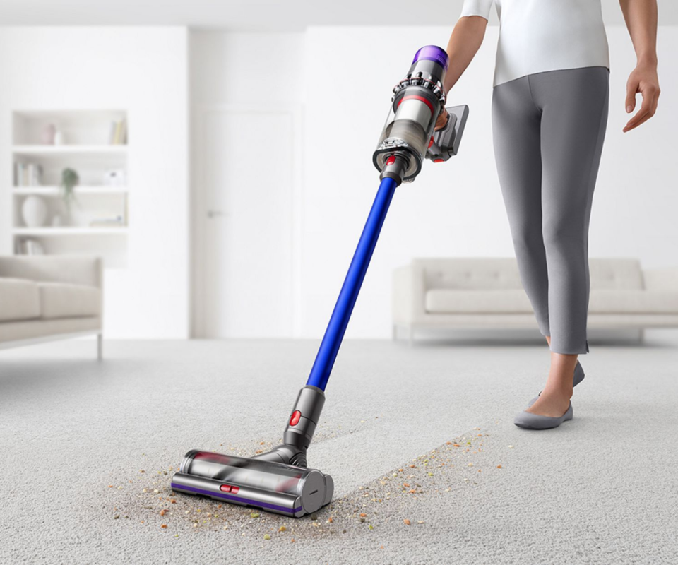 Dyson V11 Animal vacuum being pushed across a dirty carpet.