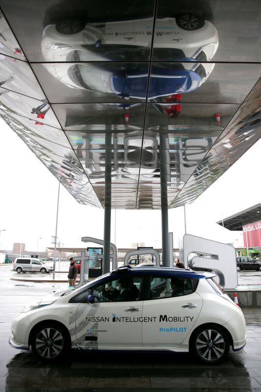 FILE PHOTO: A modified Nissan Leaf, driverless car, is reflected in an awning during a pause during its first demonstration on public roads in Europe, in London