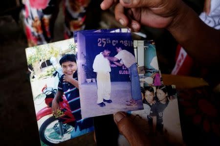 Clarita Alia, 62, shows photos of Fernando, one of four sons which have died in execution-style killings in Davao, Philippines May 14, 2016. REUTERS/Andrew RC Marshall