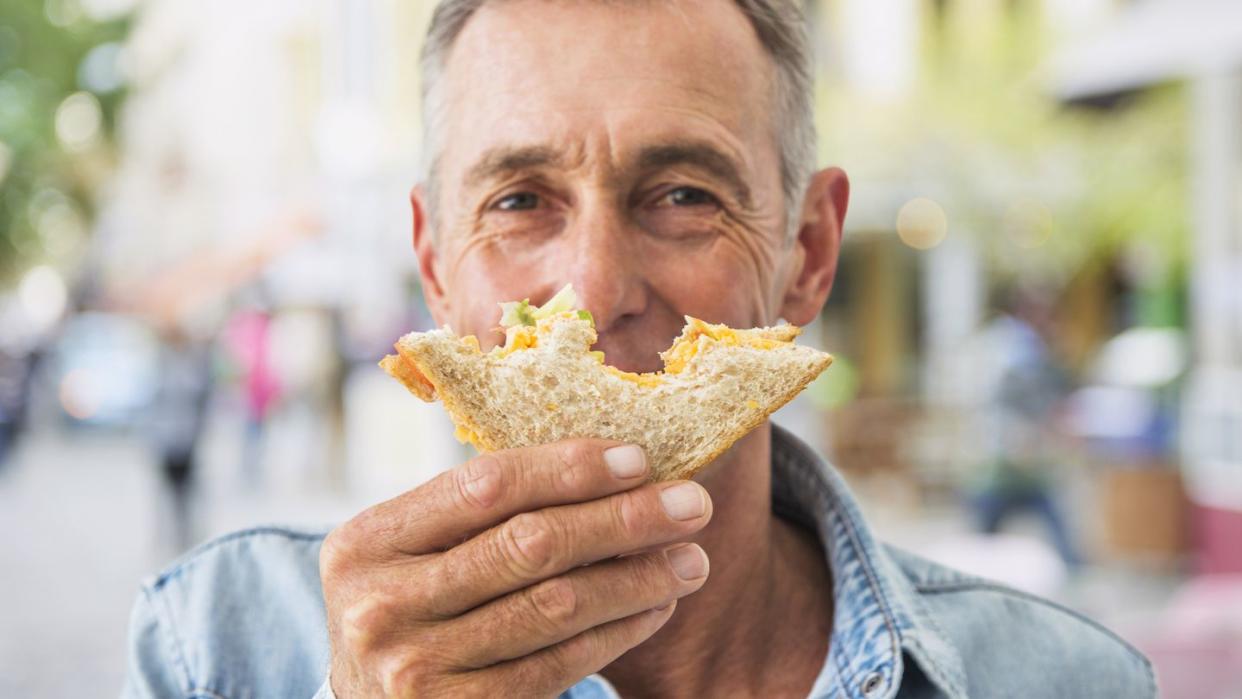 man enjoying a sandwich outdoors