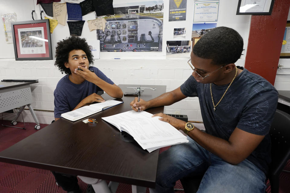 Kyan Bovee, left, goes through a post-flight briefing with instructor Tyler Gibbs, Tuesday, Sept. 5, 2023, at the Coleman A. Young airport in Detroit. The Detroit teen is part of a program that teaches young people how to fly, while exposing them to careers in aviation and as pilots...areas people of color traditionally are underrepresented. (AP Photo/Carlos Osorio)