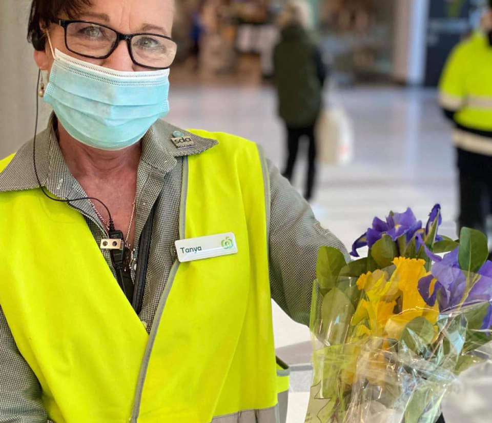 Tanya holds up a bouquet of flowers.