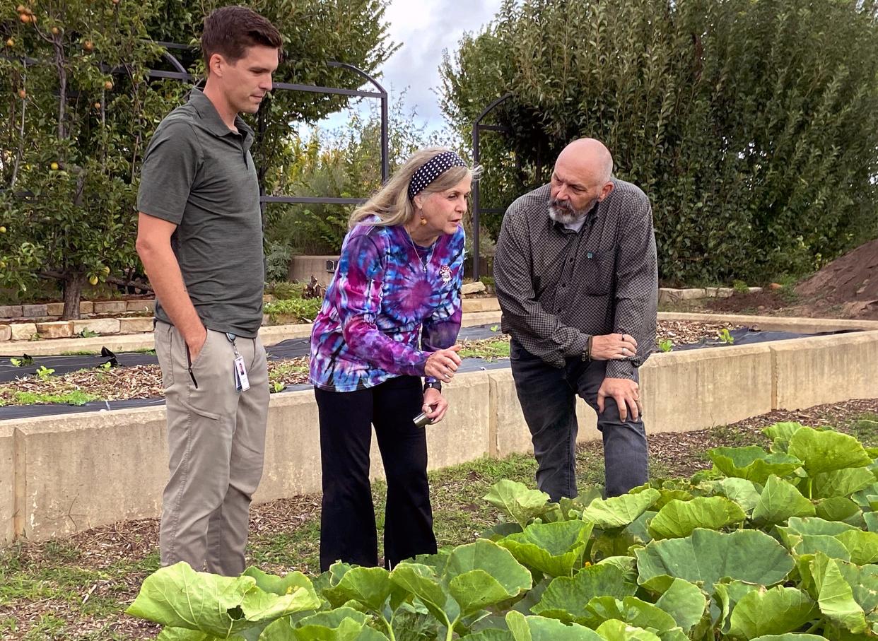 Jordan Davis, Pam Patty and Steve Petty look at a thriving bed of vegetables at the Lynn Institute Community Garden at Chesapeake, NW 62 and N Shartel Ave.
