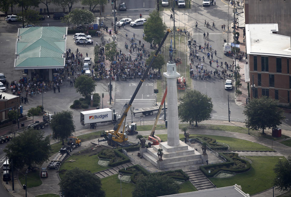 FILE -Workers prepare to take down the statue of former confederate general Robert E. Lee, which stands over 100 feet tall, in Lee Circle in New Orleans, Friday, May 19, 2017. A round patch of New Orleans green space where a larger-than-life statue of Confederate Gen. Robert E. Lee once loomed over the landscape has officially been re-named Harmony Circle. (AP Photo/Gerald Herbert, File)