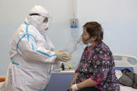 Dr. Tatyana Symbelova treats a coronavirus patient on artificial lung respiration at an intensive care unit in the red zone of the hospital in Ulan-Ude, the regional capital of Buryatia, a region near the Russia-Mongolia border, Russia, Friday, Nov. 20, 2020. Symbelova told the AP that as the number of patients rose, her hospital kept adding beds — “in the corridor, in the outpatient ward next door” — but “the situation, still, grew worse and worse.” (AP Photo/Anna Ogorodnik)