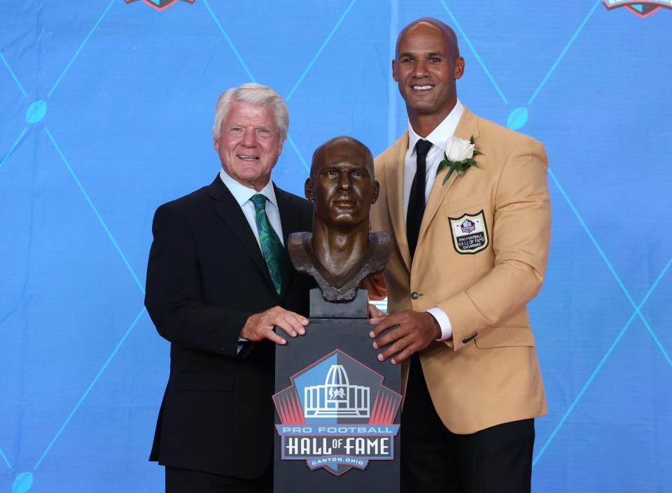 Former Dolphins linebacker/defensive end Jason Taylor (right) poses alongside his bust and former head coach, Jimmy Johnson, during the 2017 Pro Football Hall of Fame enshrinement at Tom Benson Hall of Fame Stadium.