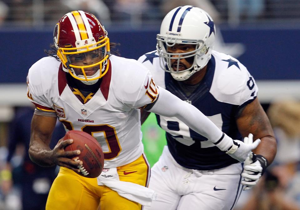 ARLINGTON, TX - NOVEMBER 22: Robert Griffin III #10 of the Washington Redskins scrambles with the ball before being sacked by Jason Hatcher #97 of the Dallas Cowboys on Thanksgiving Day at Cowboys Stadium on November 22, 2012 in Arlington, Texas. (Photo by Tom Pennington/Getty Images)