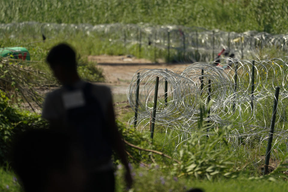 Concertina wire lines the banks of the Rio Grande at Eagle Pass, Texas, Friday, Aug. 26, 2022. The area has become entangled in a turf war between the Biden administration and Texas Gov. Greg Abbott over how to police the U.S. border with Mexico. (AP Photo/Eric Gay)