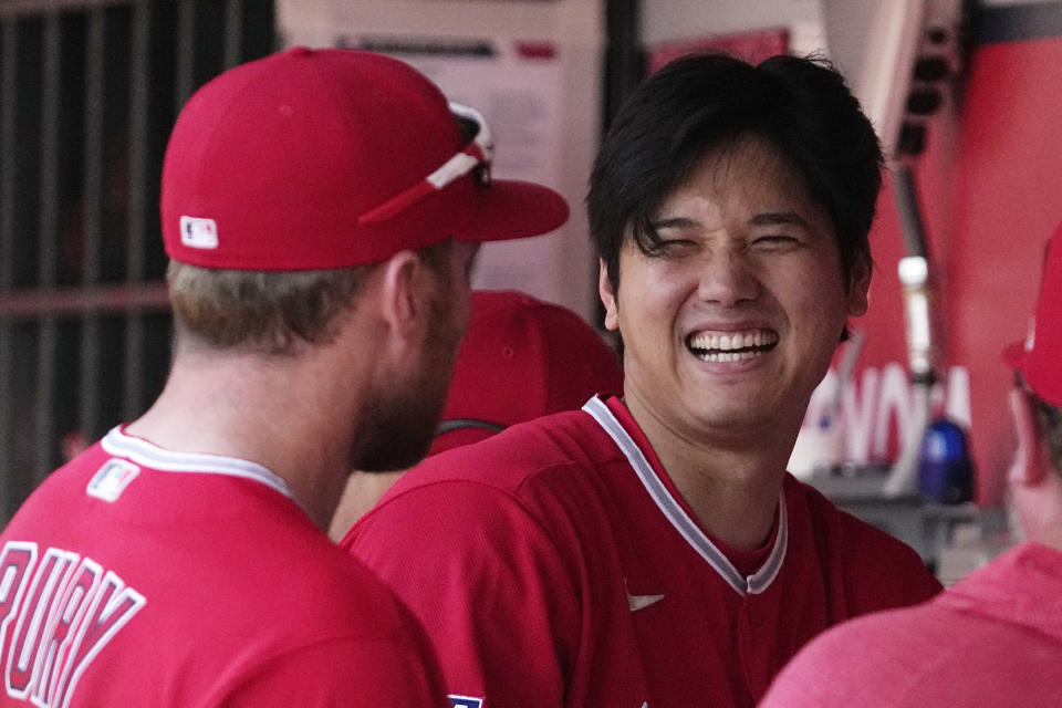 Los Angeles Angels' Shohei Ohtani talks to Brandon Drury in the dugout prior to a baseball game against the Kansas City Royals Sunday, April 23, 2023, in Anaheim, Calif. (AP Photo/Mark J. Terrill)