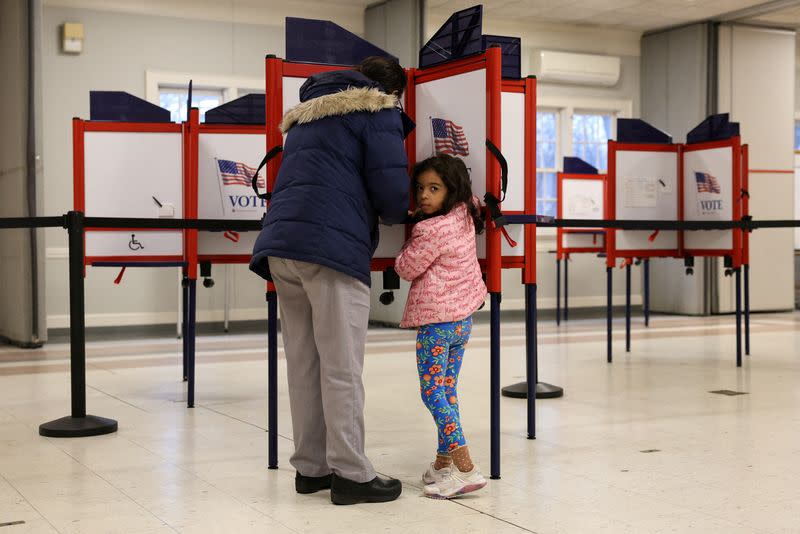 Sophie Townes, de 5 años, mira mientras su madre Katie vota durante las elecciones primarias del Supermartes, en Topsfield, Massachusetts