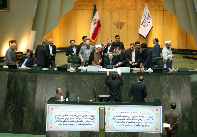 Iran's Parliament Speaker Ali Larijani (C) listens to a deputy during the key session in Tehran on October 13, 2015