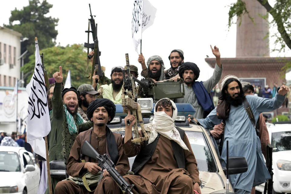 Taliban fighters celebrate one year since they seized the Afghan capital, Kabul, in front of the U.S. Embassy in Kabul, Afghanistan, Monday, Aug. 15, 2022. The Taliban marked the first-year anniversary of their takeover after the country's western-backed government fled and the Afghan military crumbled in the face of the insurgents' advance. (AP Photo/Ebrahim Noroozi)