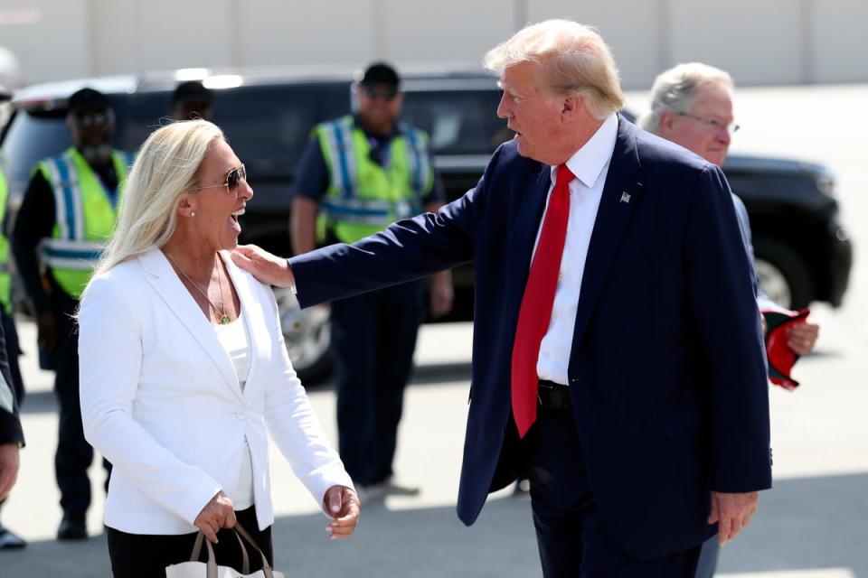 Former President Donald Trump is greeted by Rep. Majorie Taylor Greene, R-Ga., as he arrives at Atlantic Aviation CHS in North Charleston, S.C., Saturday, Sept. 25, 2023 (AP)