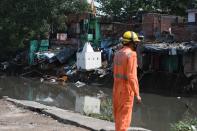 A National Disaster Response Force personnel inspects the area where some shanty houses collapsed into a canal due to heavy rains in New Delhi on July 19, 2020. (Photo by Sajjad HUSSAIN / AFP) (Photo by SAJJAD HUSSAIN/AFP via Getty Images)