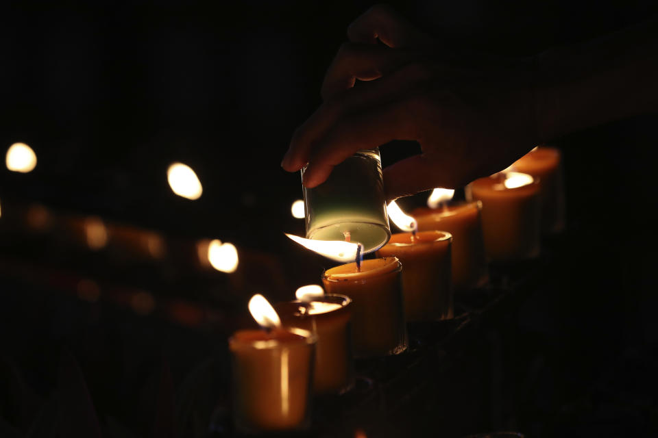 In this Friday, Oct. 18, 2019, photo, Catholic devotees light candles as they pray during the 30th anniversary of the beatification of the seven martyrs at Songkhon village in Mukdahan province, northeastern Thailand. In 1940, seven villagers here were executed for refusing to abandon their Catholic faith, which Thai nationalists had equated with loyalty to France, whose colonial army in neighboring Indochina had fought Thailand in a brief border war. The seven were beatified in 1989 by Pope John Paul II, the first step to being named a saint. (AP Photo/Sakchai Lalit)