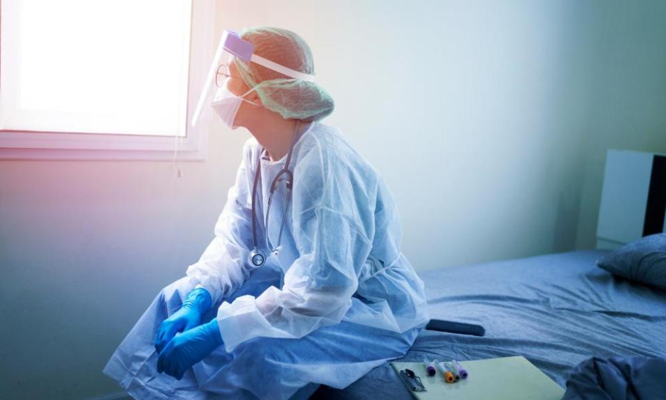 A doctor wearing PPE looking sad.