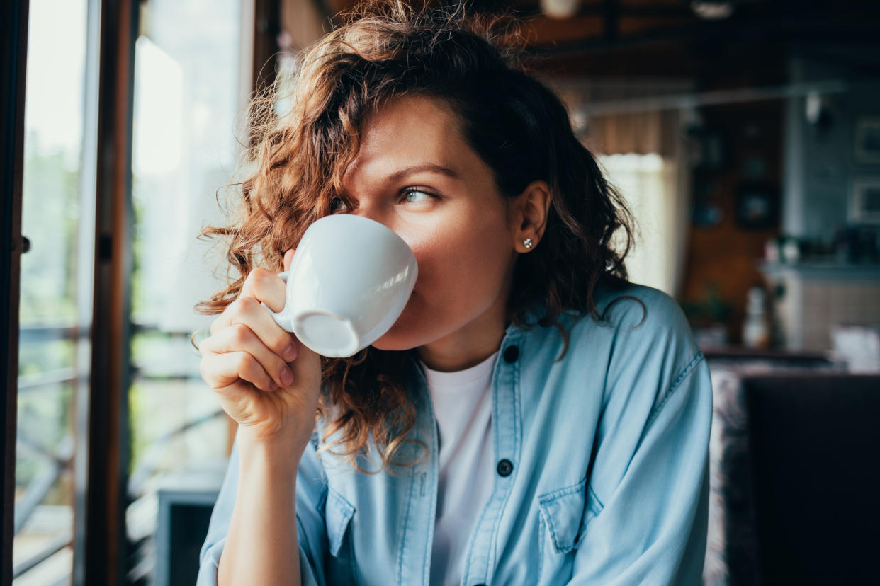 Woman drinking a cup of coffee. (Getty Images)