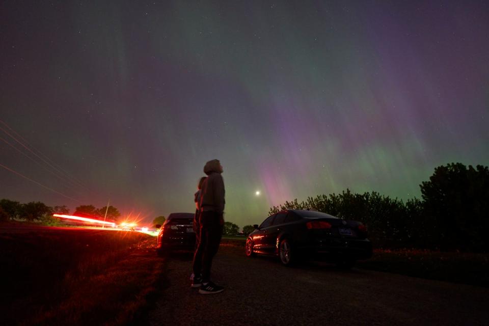 People stop along a country road near London, Ontario to watch the Northern lights or aurora borealis during a geomagnetic storm on May 10, 2024 (AFP via Getty Images)