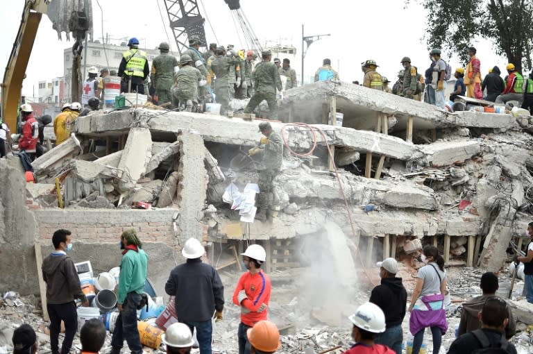 Rescuers clear rubble and debris from the site where a multistory building was flattened by the 7.1-magnitude quake