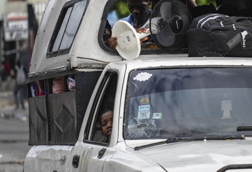 Residents use a "tap-tap" public transport vehicle to carry some of their house items as they evacuate the Delmas 22 neighborhood to escape gang violence in Port-au-Prince, Haiti, Thursday, May 2, 2024. (AP Photo/Ramon Espinosa)